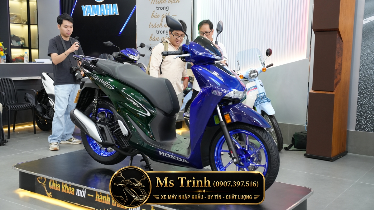 Hiệu ứng hai màu trên Honda SH150i Super Vetro 2 in 1 Góc quan sát thể hiện sự chuyển đổi giữa Sapphire và Vetro Green trên SH150i