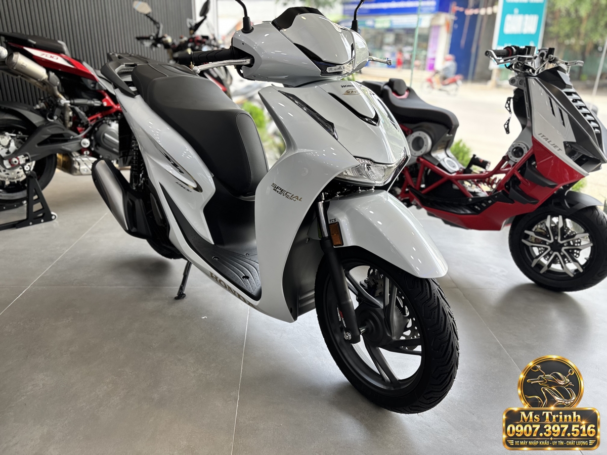 Honda SH150 Ý màu trắng 2027 nhìn nghiêng với mâm đen Honda SH150 Ý màu trắng đời 2027 nhìn nghiêng với dàn áo trắng, mâm đúc đen và yên dài
